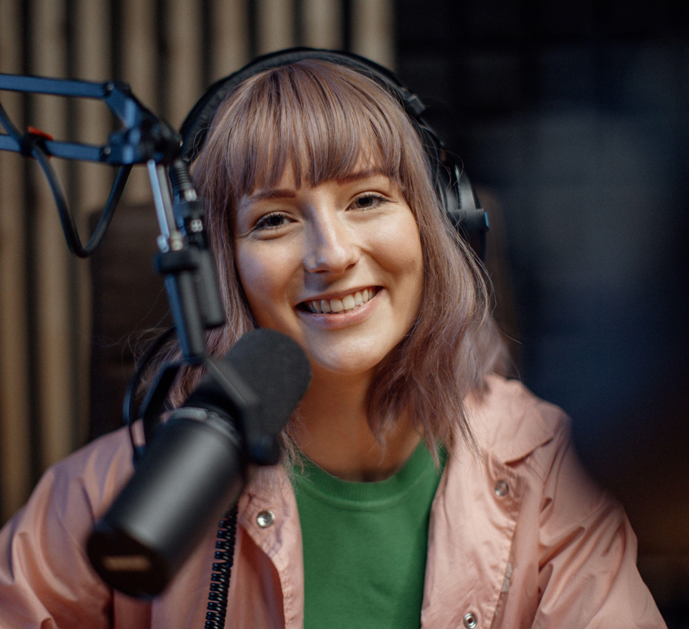 Podcasterin sitzt vor dem Mikrofon